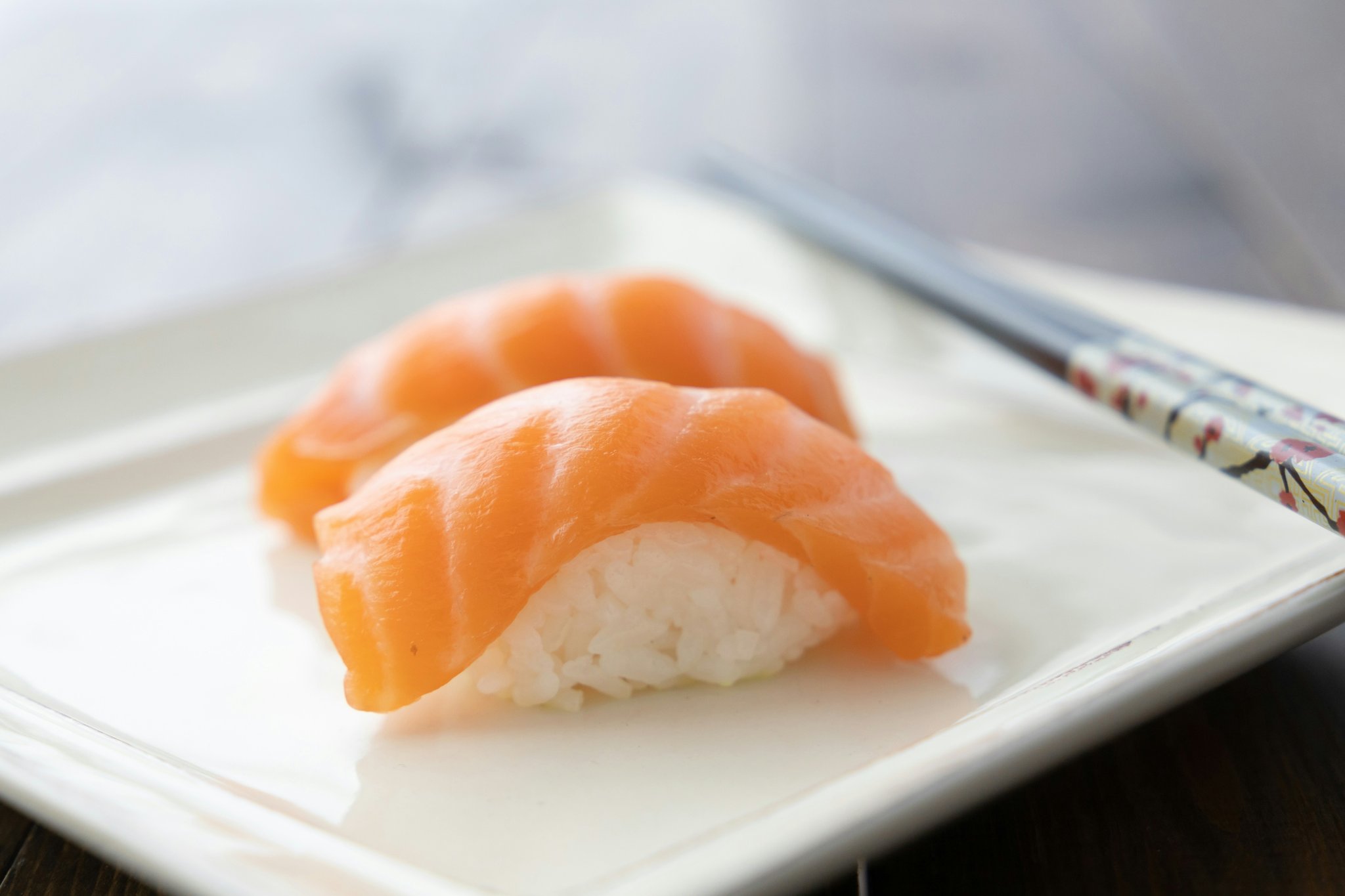 A close-up shot of a person holding a mat splitter while brushing a cat