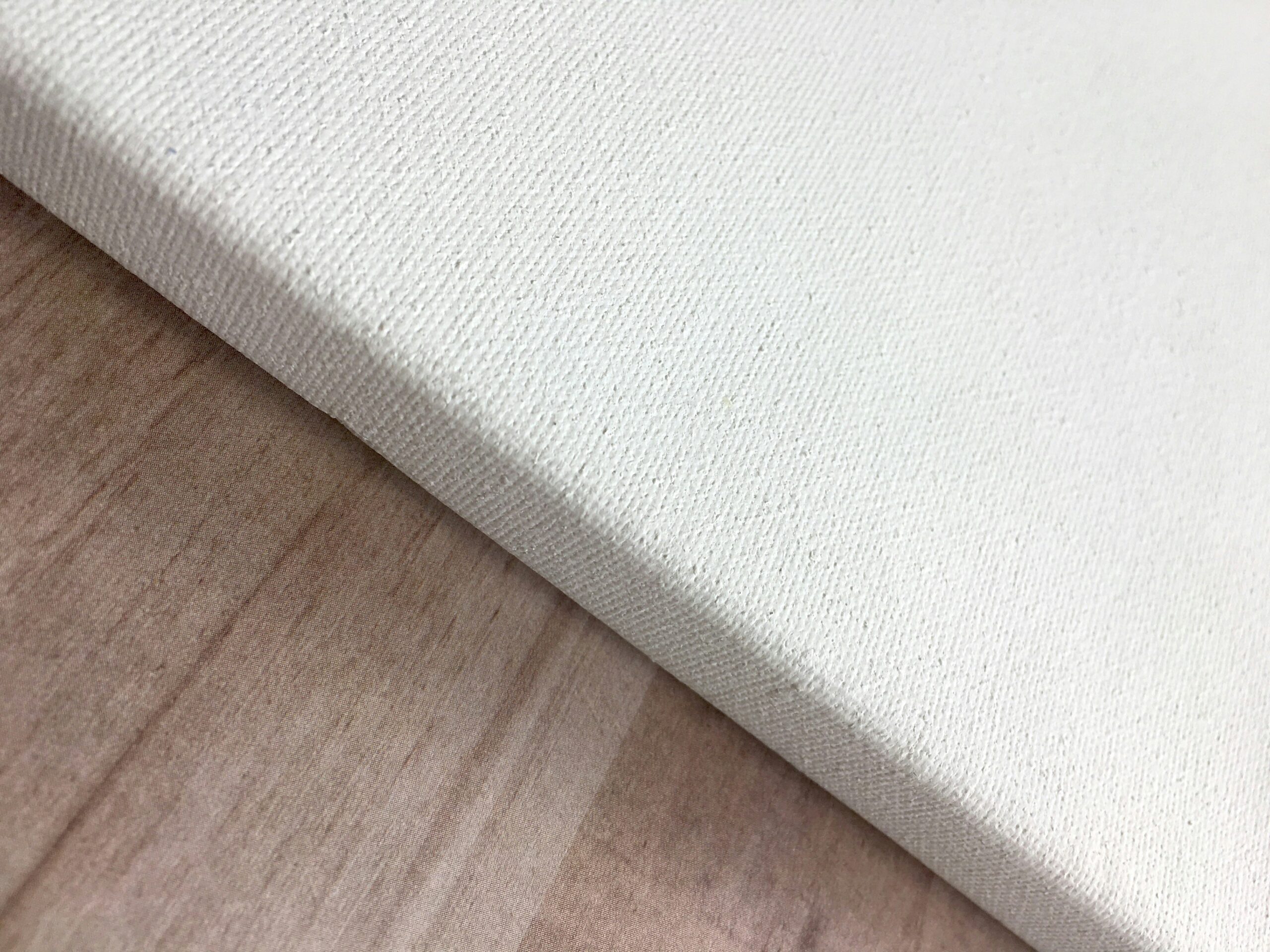 a close up of a white canvas on a wooden surface