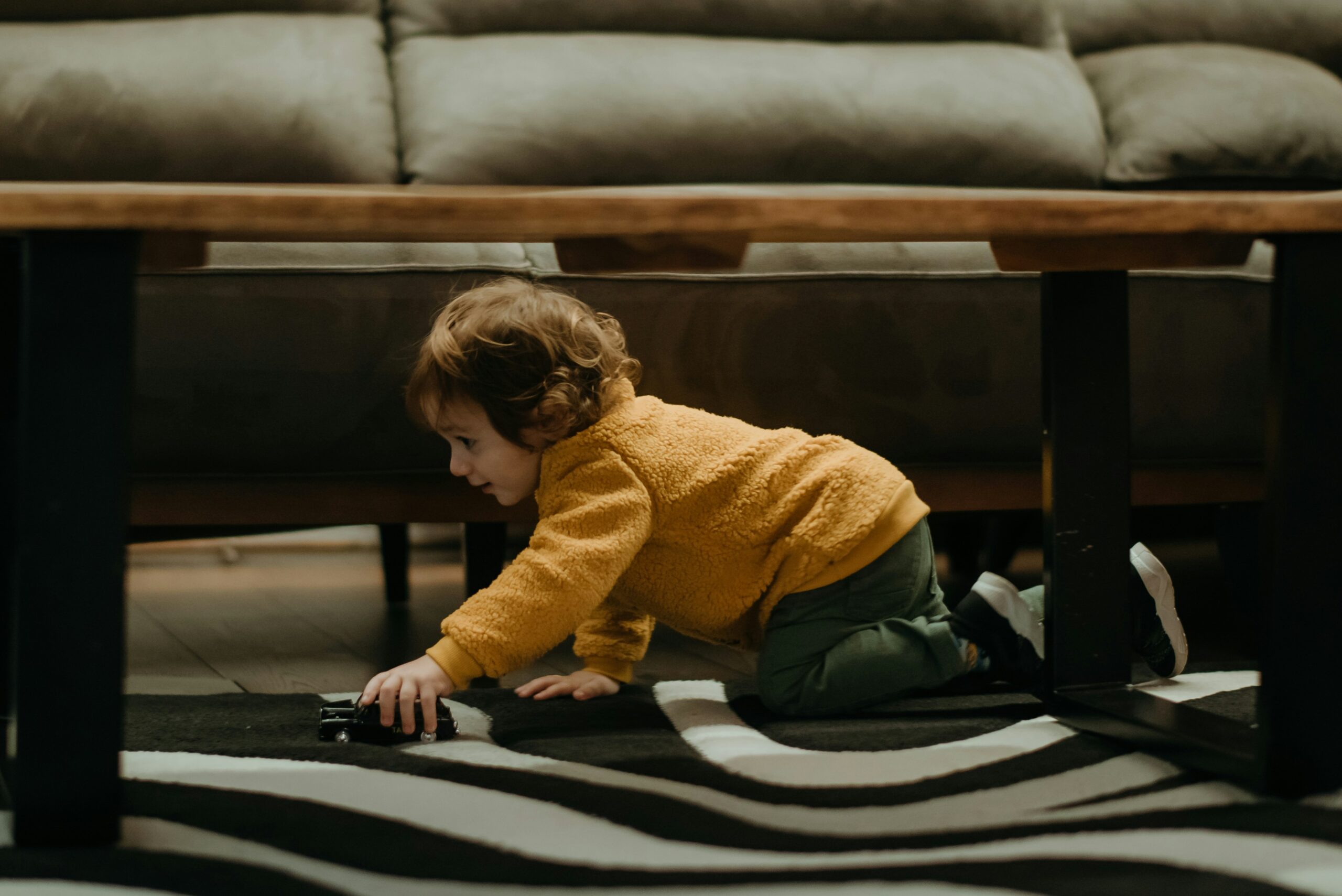 a small child playing with a laptop on the floor